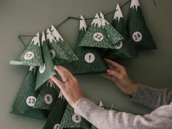 Dame henger opp julekalender på veggen