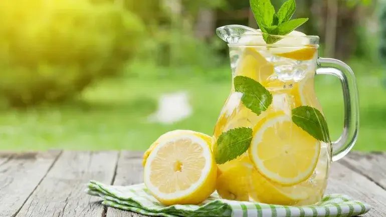 sitronsaft i en mugge og masse sitroner