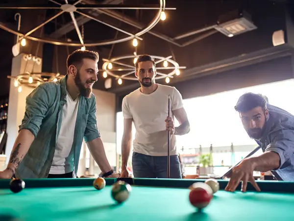 Friends playing billiards together