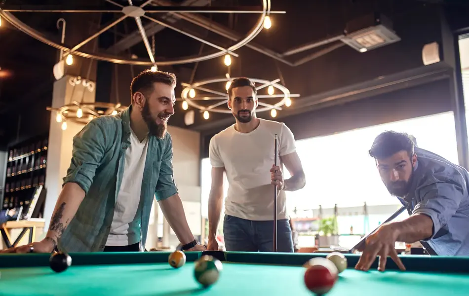 Friends playing billiards together