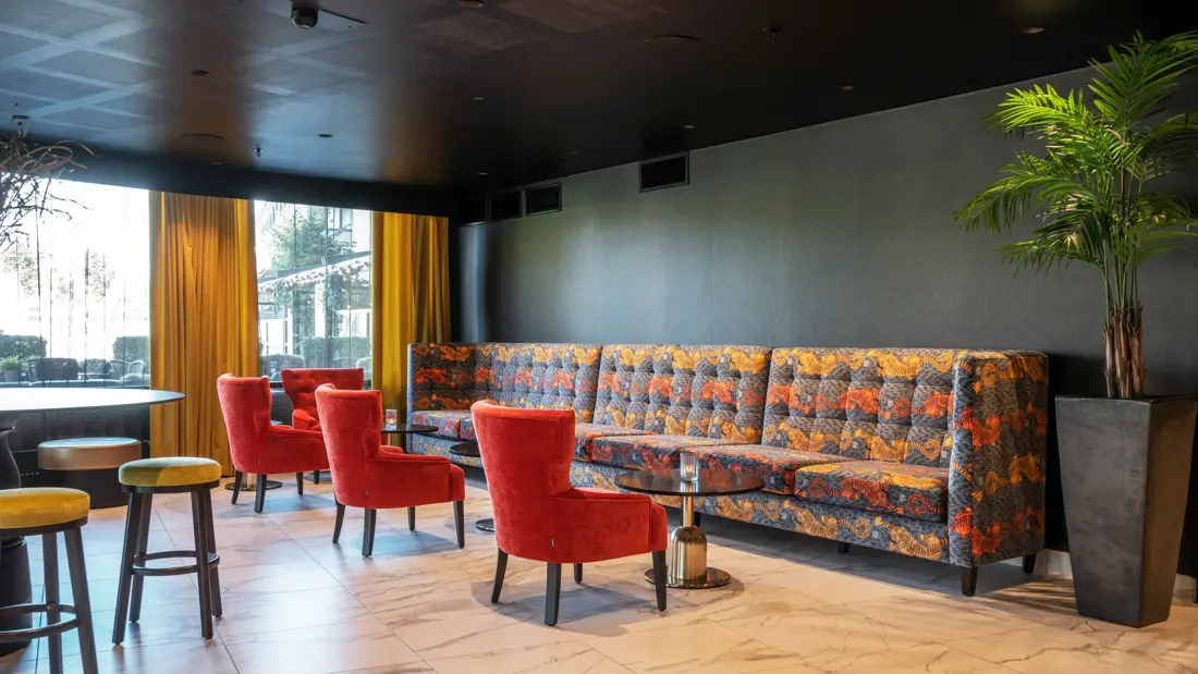 Røde lenestoler, sofa, salongbord, vindu 