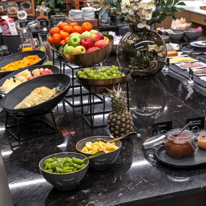 Frokostbuffet med diverse fargerike oppskåret frukt og grønnsaker