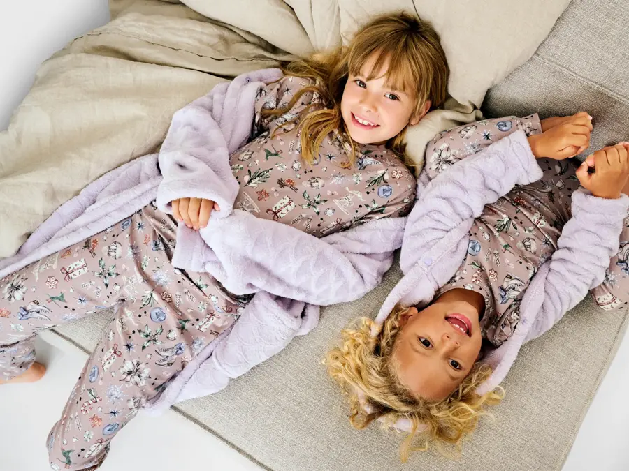 To jenter som ligger på en sofa