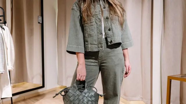 dame i vårklær står ved prøverom