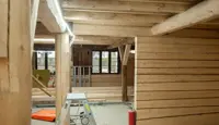 1. etasje i Kjøpmannsgata 15 i Trondheim; nytt og restaurert tre i skjønn forening. Trappestige og materialer ligger på betonggulvet. Vinduer retning Kjøpmannsgata.
