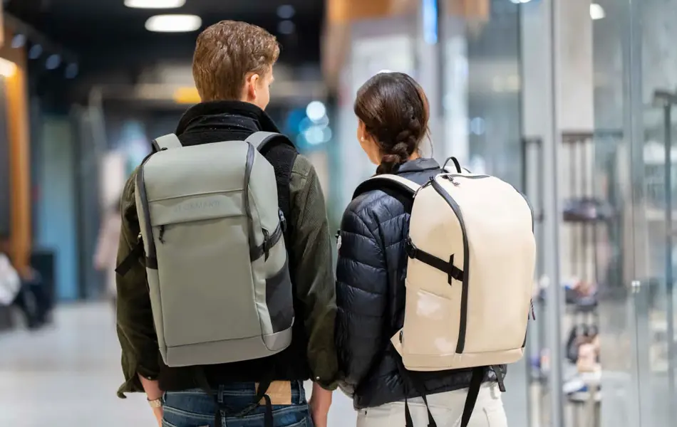 Tenåringsgutt med jakke og grå sekk, tenåringsjente med boblejakke og lysebeige sekk