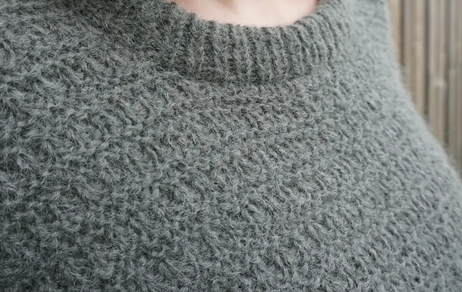 Nærbilde av grønn strikket genser