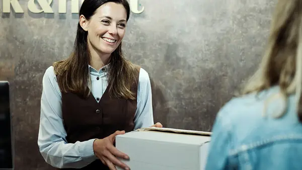 Dame fyller ut varer på vinmonopolet