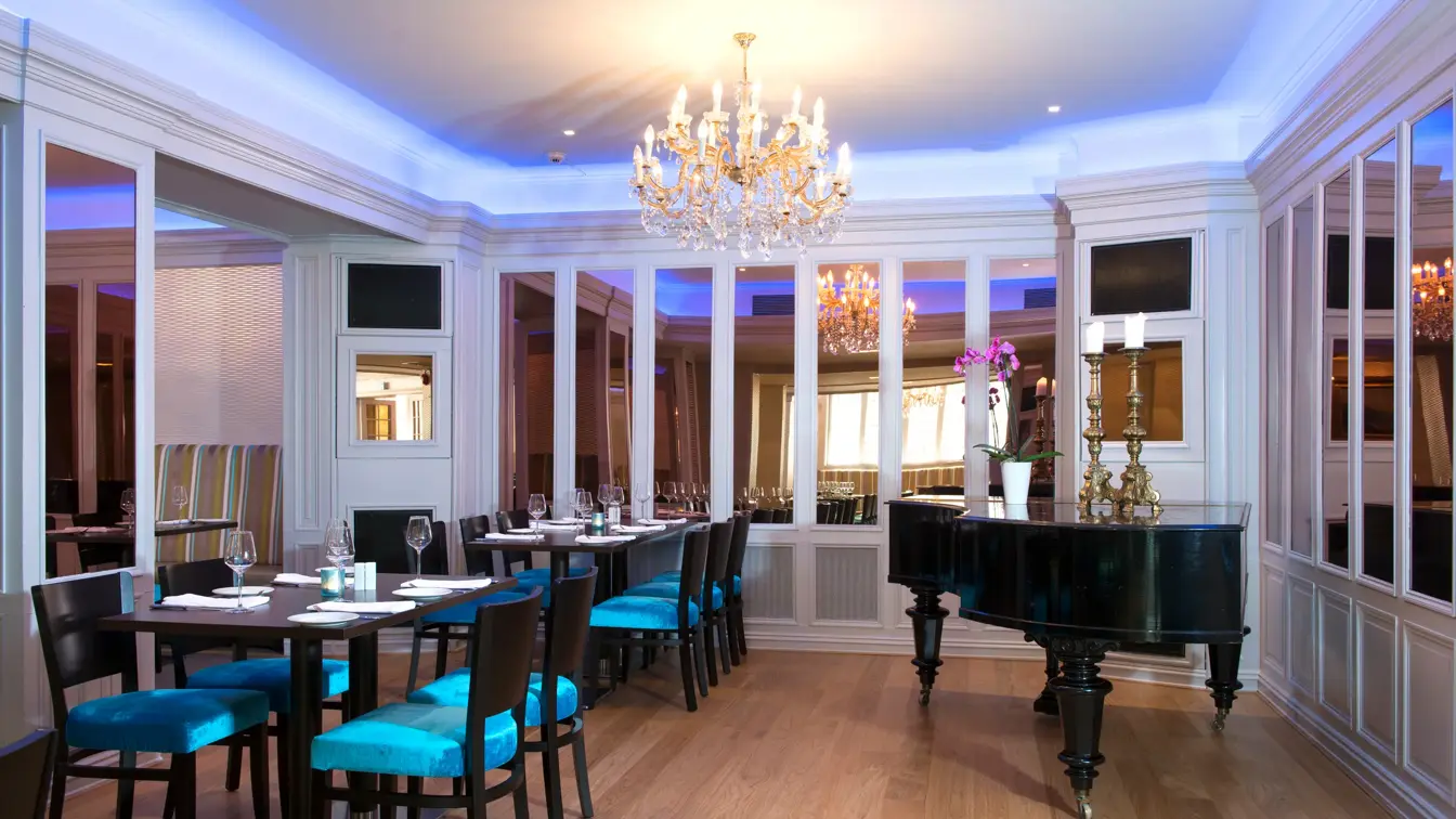 Frokostsal med lyskroner, piano og dekket bord på Thon Hotel Slottsparken like ved Karl Johan