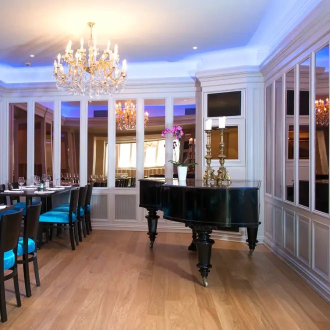 Frokostsal med lyskroner, piano og dekket bord på Thon Hotel Slottsparken like ved Karl Johan