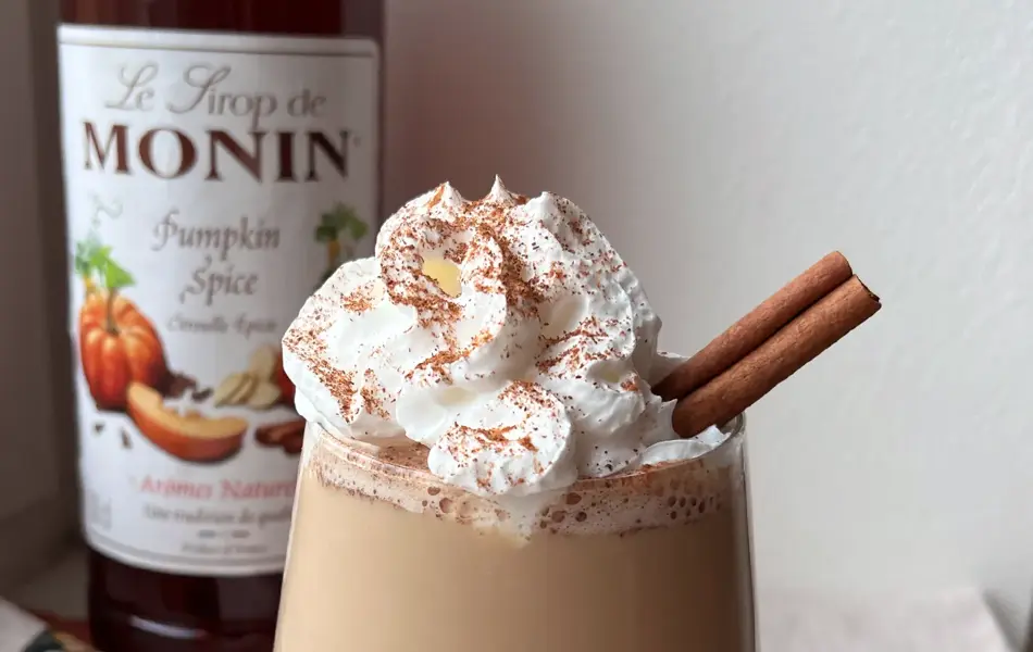 Kaffe med krem og dekorert med kanel på toppen