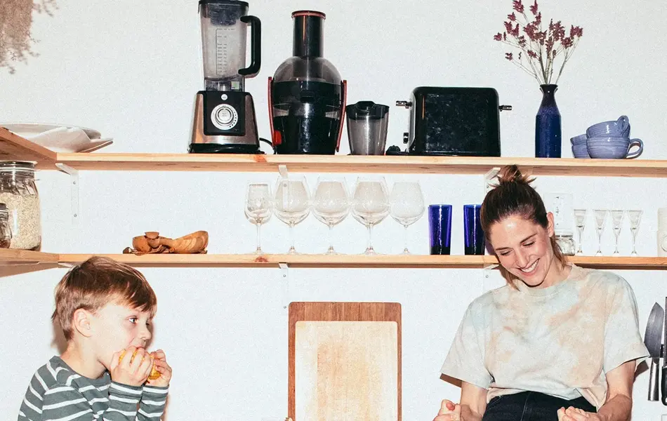 Familie med mor og to små gutter leker på kjøkken 