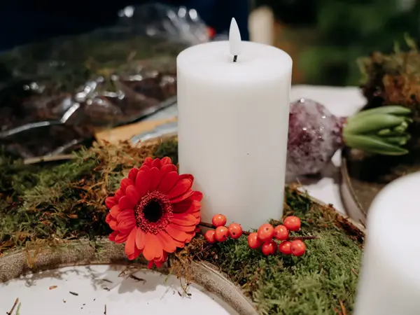 batteridrevent lys, med pynteblomster og bær