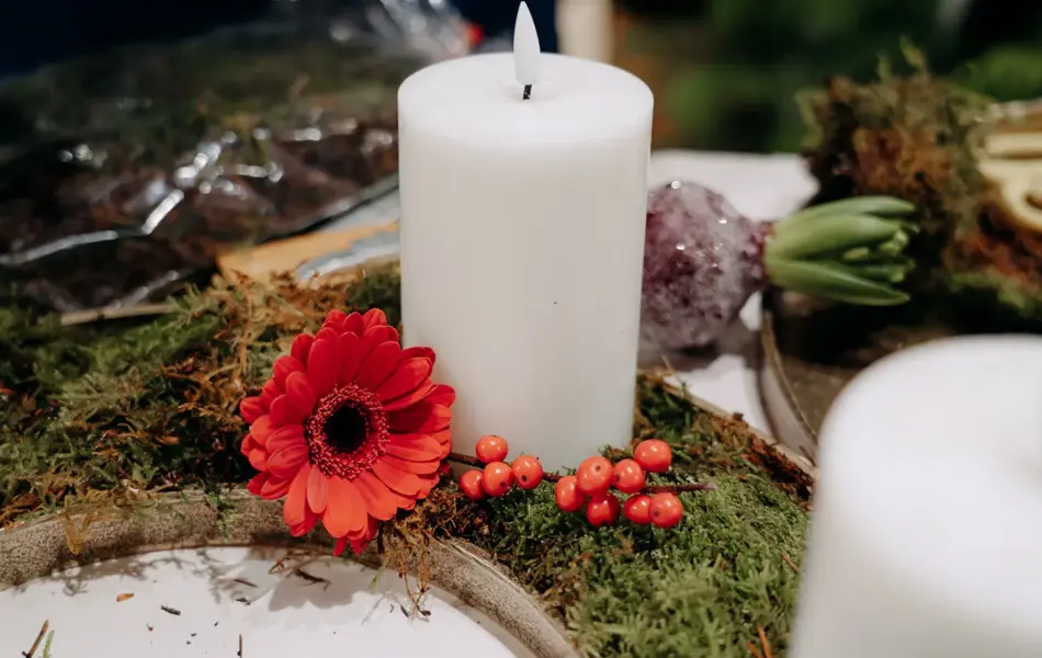 batteridrevent lys, med pynteblomster og bær