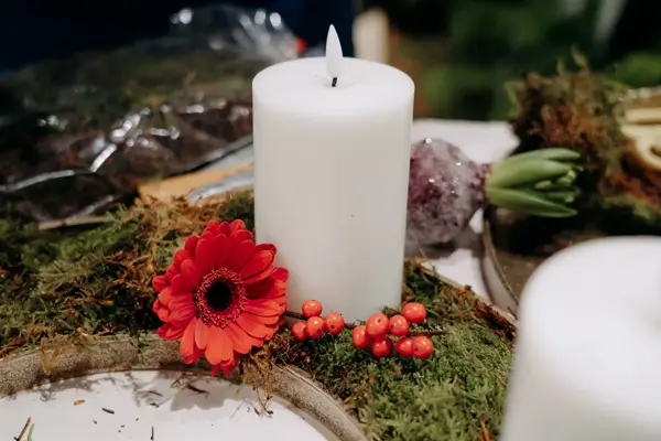 batteridrevent lys, med pynteblomster og bær