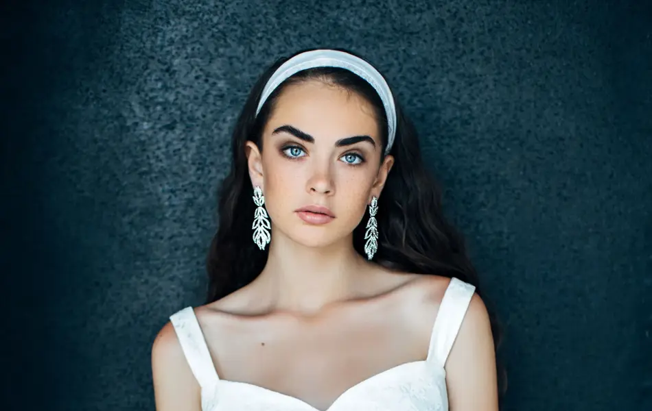 Modell poserer med hvit kjole og hårbøyle