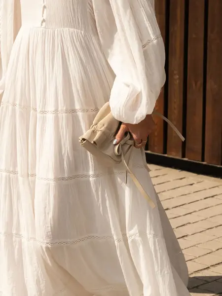 Dame i kjole som holder en håndveske