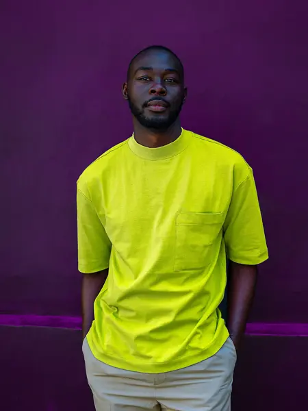 Mann i grønn t-skjorte foran lilla vegg