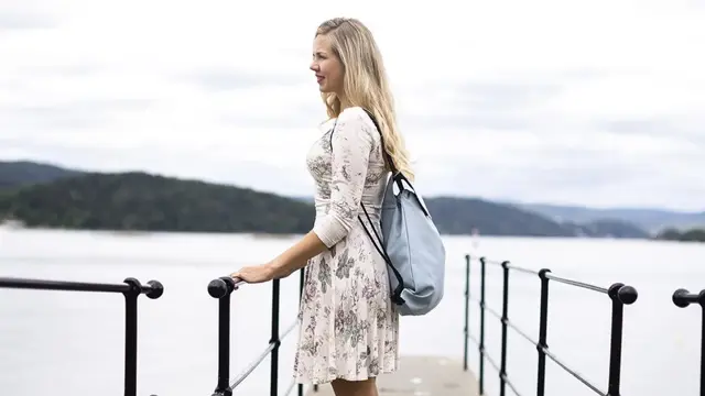 dame på brygge med bag på ryggen