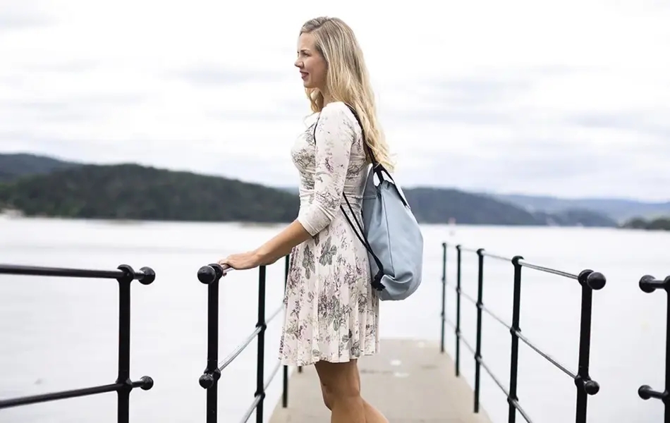 dame på brygge med bag på ryggen