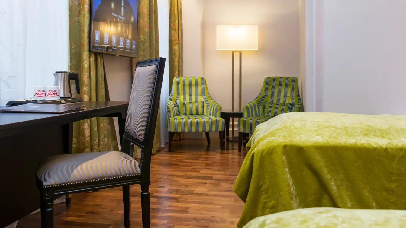 To enkeltsenger, skrivepult og to lenestoler på Hotel Bristol i Oslo sentrum