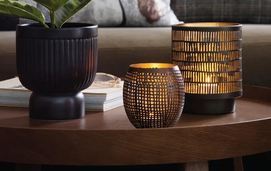 Sofa med bord dekket med grønn plante og lykter