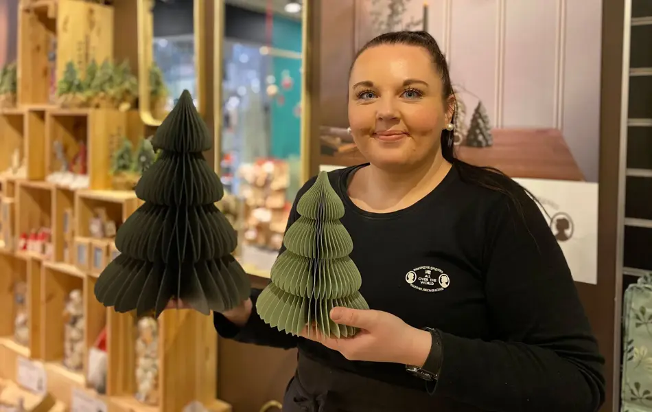 ansatt hos søstrene grene viser julepynten to grønne papirtrær