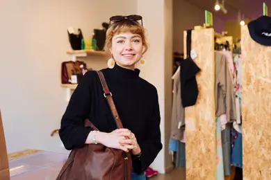 Kunde i buktbutikk prøver en skinnveske