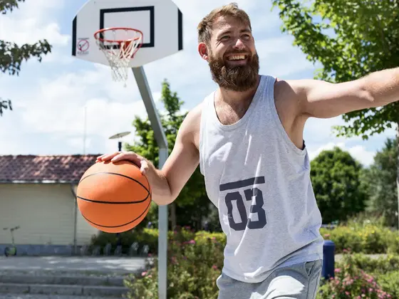 Mann med lys grå singlet med tallet 3 på spiller basket 