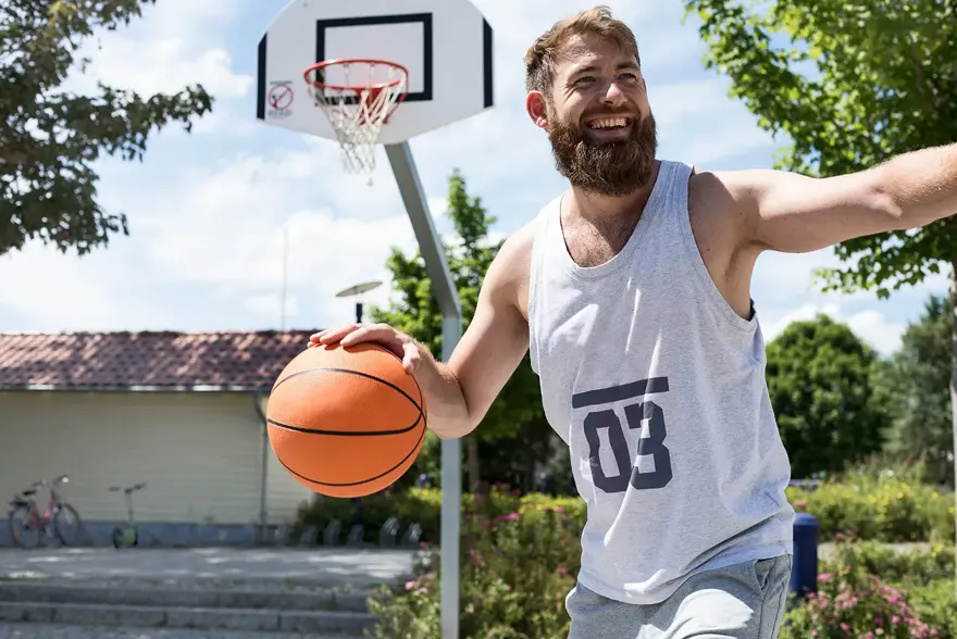 Mann med lys grå singlet med tallet 3 på spiller basket 