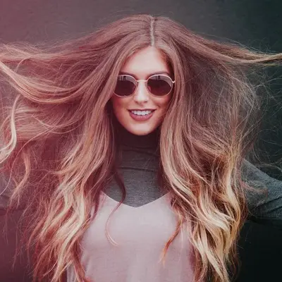 Dame drar håret sitt fra hver sin sine