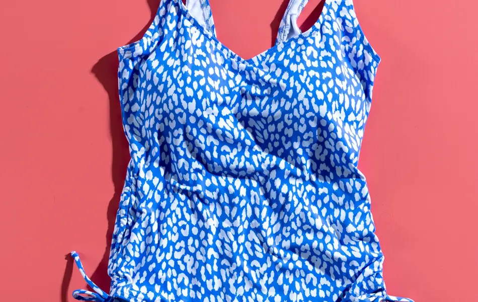 Blå og hvit spraglete badedrakt på rosa bakgrunn