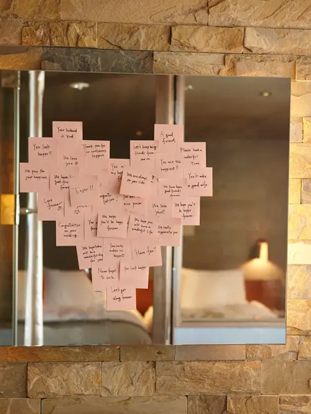 Lyserosa post-it-lapper plassert i en hjerteform på et speil