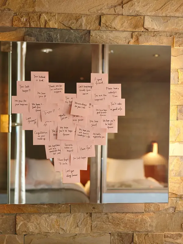 Lyserosa post-it-lapper plassert i en hjerteform på et speil