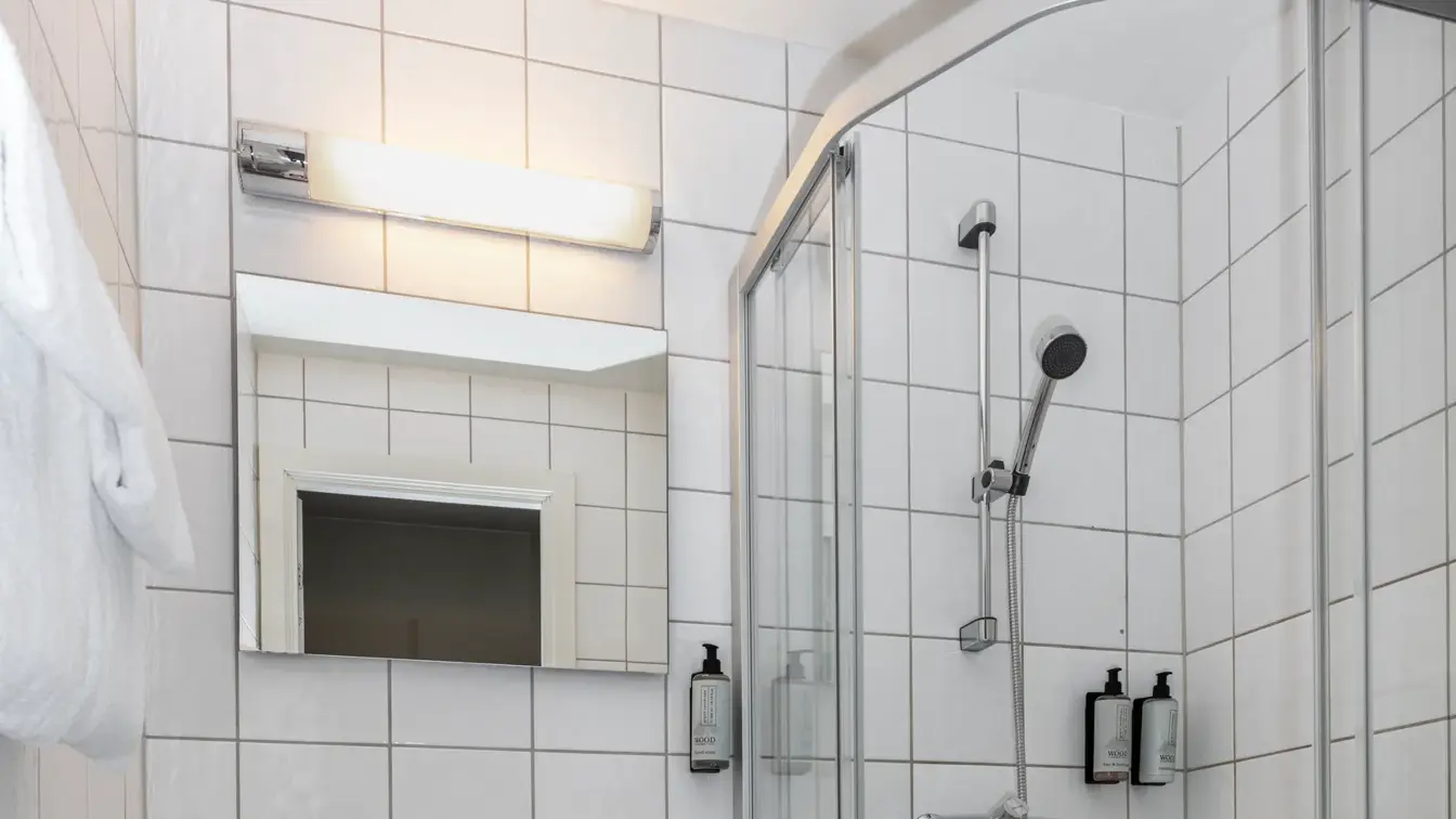 Bad med dusjkabinett, servant, speil og toalett.