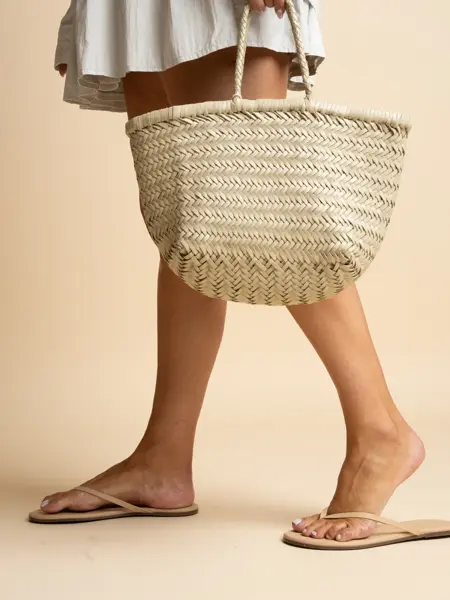 Dameben med flip flops, hånd holder stråveske