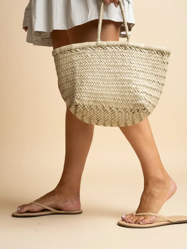 Dameben med flip flops, hånd holder stråveske