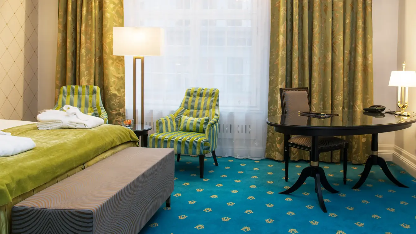 Dobbeltseng og to gode lenestoler på Hotel Bristol i Oslo sentrum