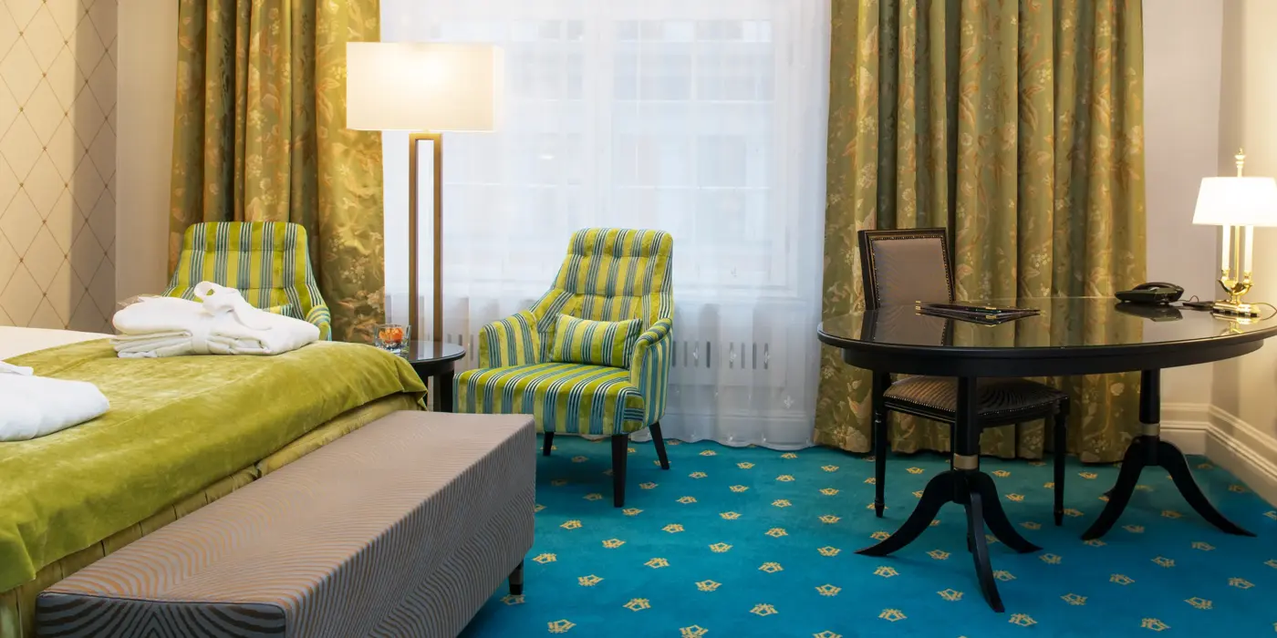 Dobbeltseng og to gode lenestoler på Hotel Bristol i Oslo sentrum