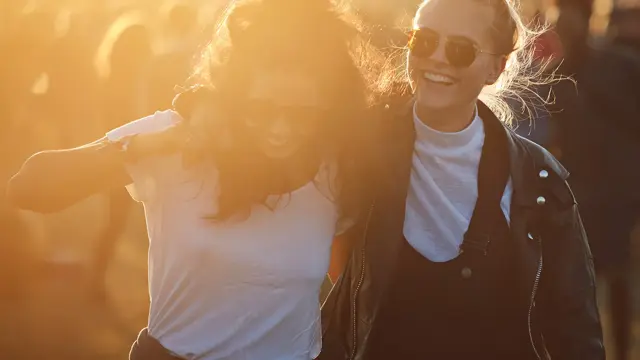 To venninner smiler og koser seg på festival