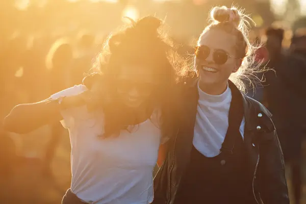 To venninner smiler og koser seg på festival