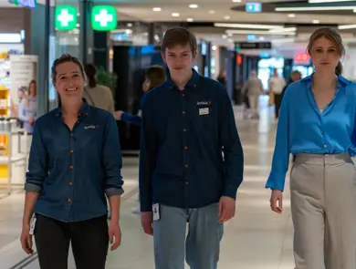 tre mennesker går i gangen på ØStfoldhallene