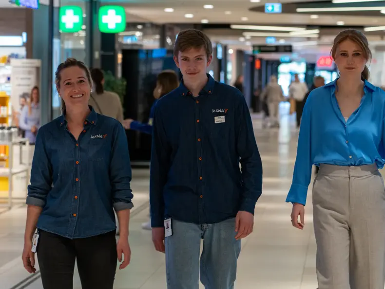 tre mennesker går i gangen på ØStfoldhallene