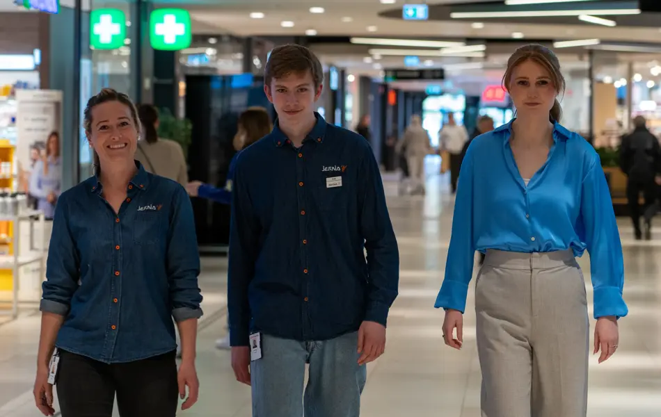 tre mennesker går i gangen på ØStfoldhallene