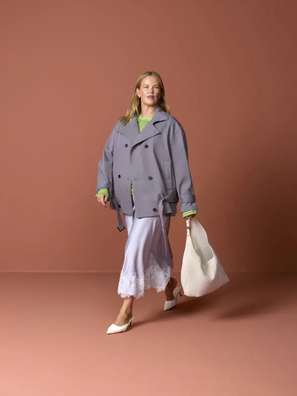 Elen med grå jakke, lyst skjørt, pumps og stor veske