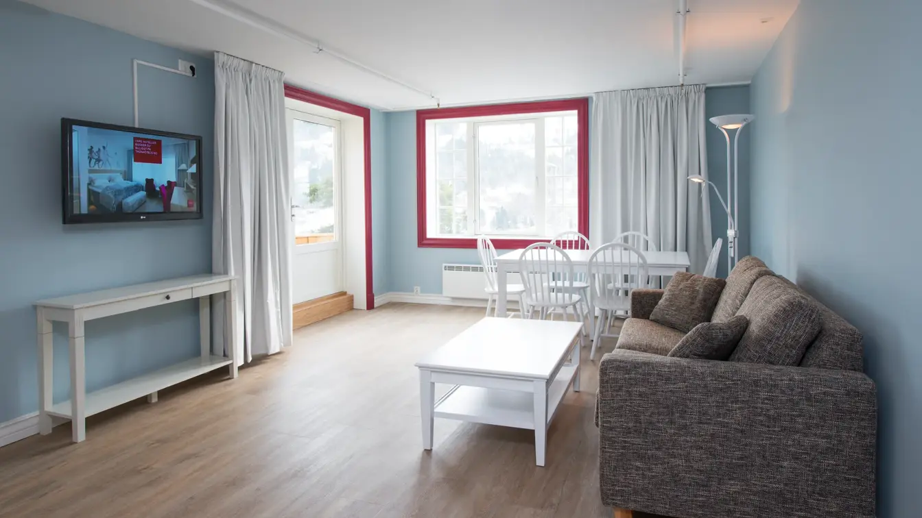 Sofa, bord og TV i suite på Thon Hotel Hallingdal