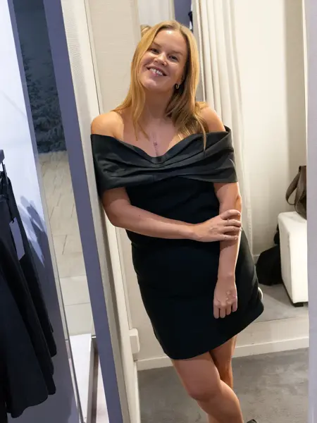 Dame med sort off-shoulder kort kjole.