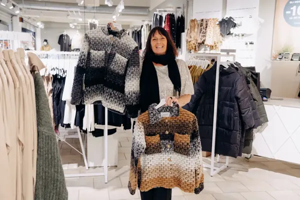 ansatt viser frem utvalg av jakker