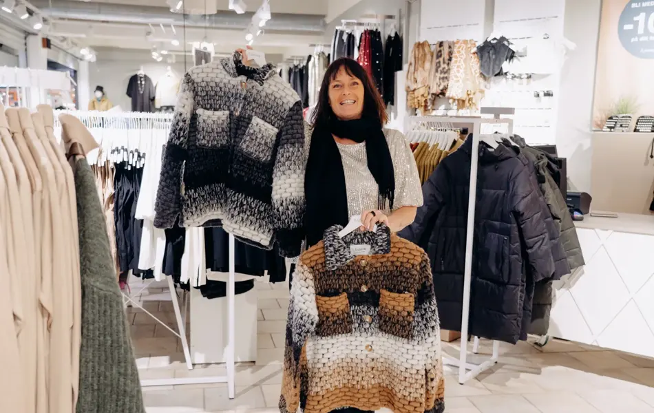 ansatt viser frem utvalg av jakker