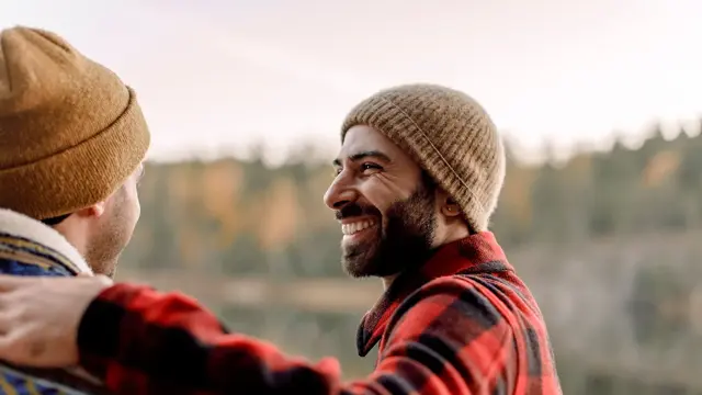 Nærbilde av mann i profil med rødrutete flanellskjorte.  